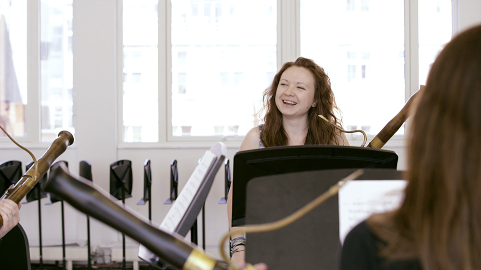 Performer smiling during a bassoon ensemble rehearsal